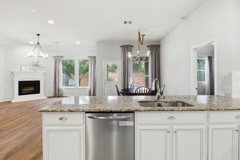 a kitchen with kitchen island granite countertop a stove a sink and a granite counter tops
