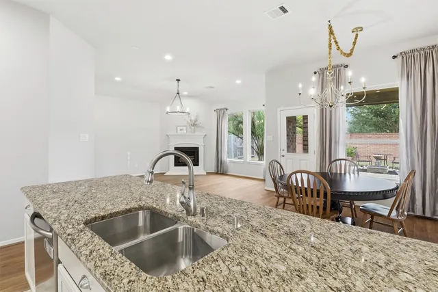 a kitchen with a stove a faucet a dining table and chairs
