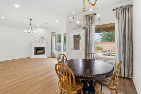 a dining room with furniture a chandelier and wooden floor