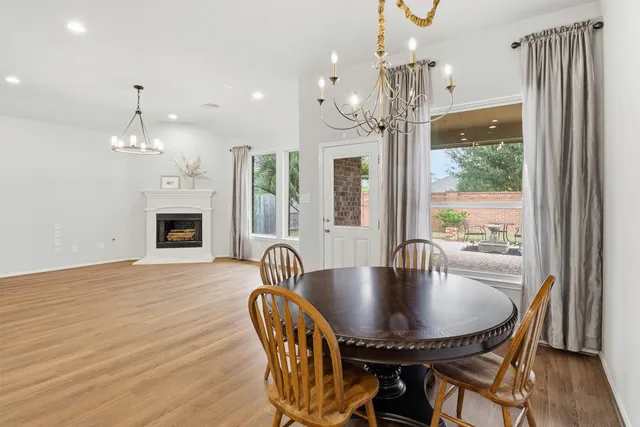 a dining room with furniture a chandelier and wooden floor