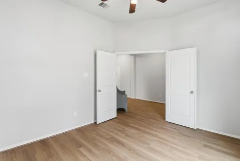 a view of an empty room with wooden floor