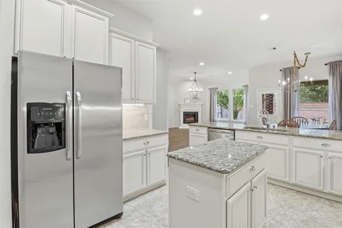 a kitchen with a refrigerator sink and cabinets