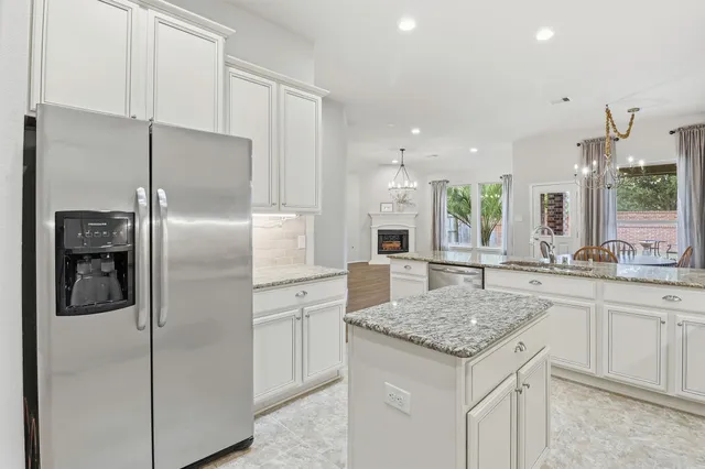 a kitchen with a refrigerator sink and cabinets