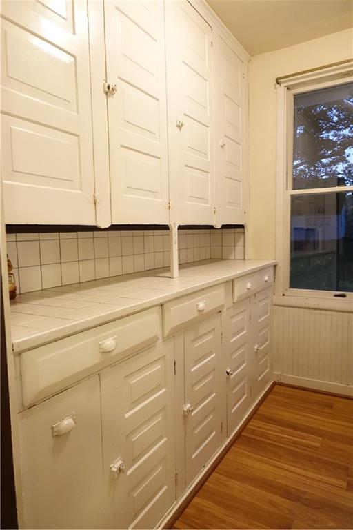 172 Cupps Road Renfrew, PA 16053 - Photo 8 of 25 a view of a kitchen with dishwasher and white cabinets with wooden floor