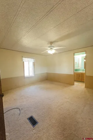 an empty room with windows and ceiling fan view