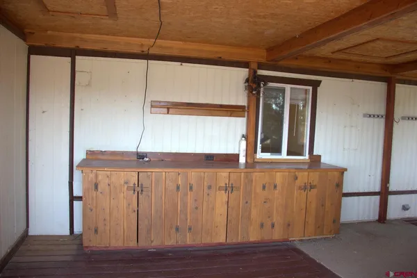 a view of a terrace with a table and chairs under an umbrella