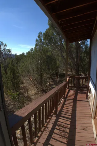 a balcony with wooden floor and yard in the back