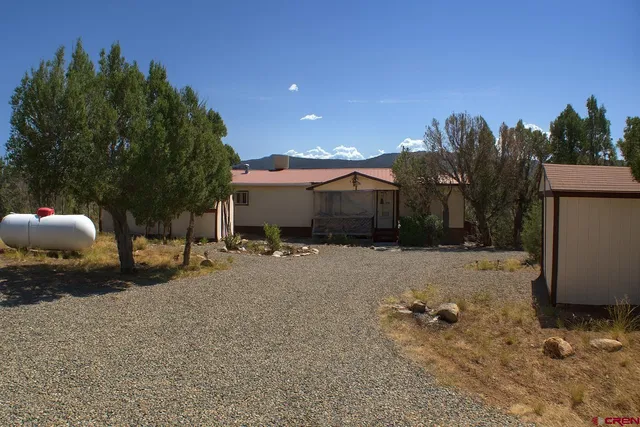 a view of a house with a yard and tree s