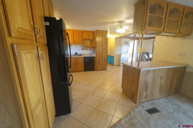 a view of a kitchen with furniture and a refrigerator