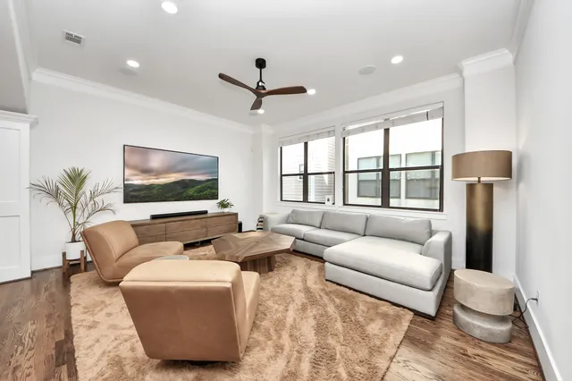 a living room with furniture ceiling fan and a flat screen tv