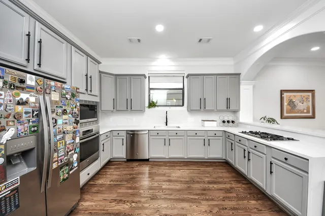 a kitchen with stainless steel appliances granite countertop a stove top oven a sink dishwasher and a refrigerator