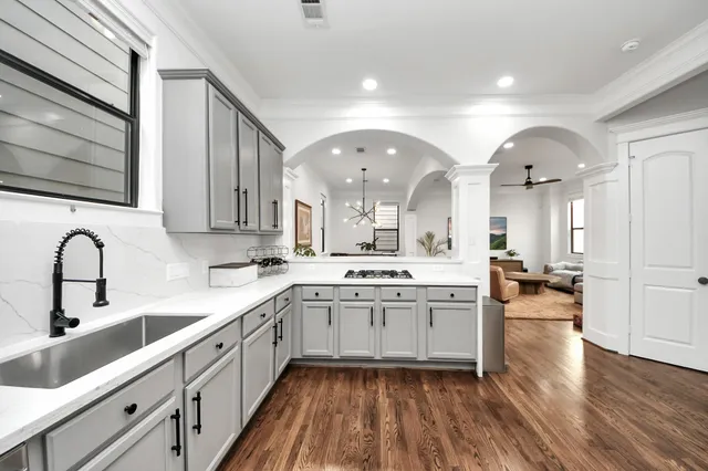 a large kitchen with a lot of counter space and wooden floor