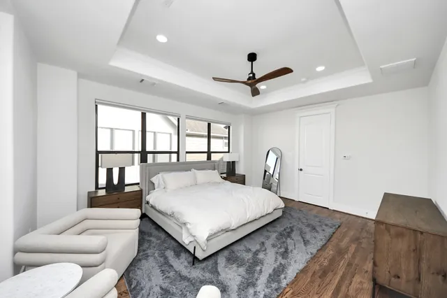 a spacious bedroom with a large bed and a chandelier