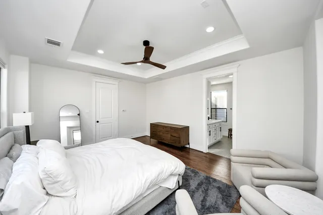 a bedroom with a large bed and a chandelier