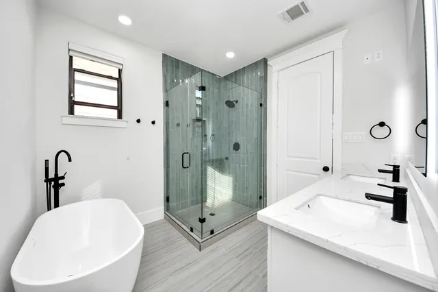 a bathroom with a granite countertop sink a toilet a mirror and shower