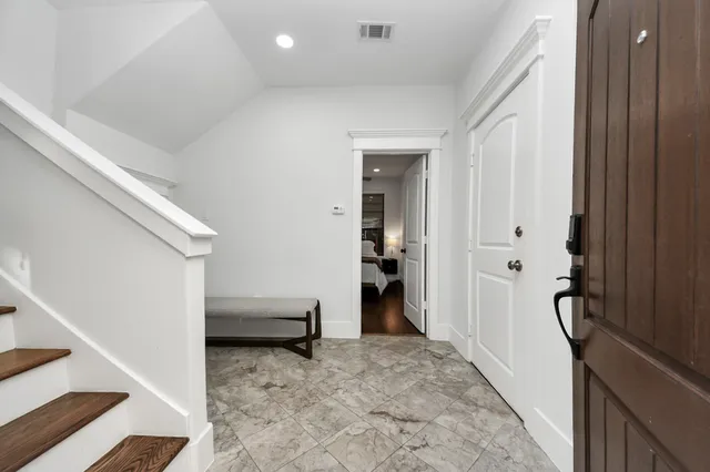 a view of a hallway to a livingroom with furniture and windows