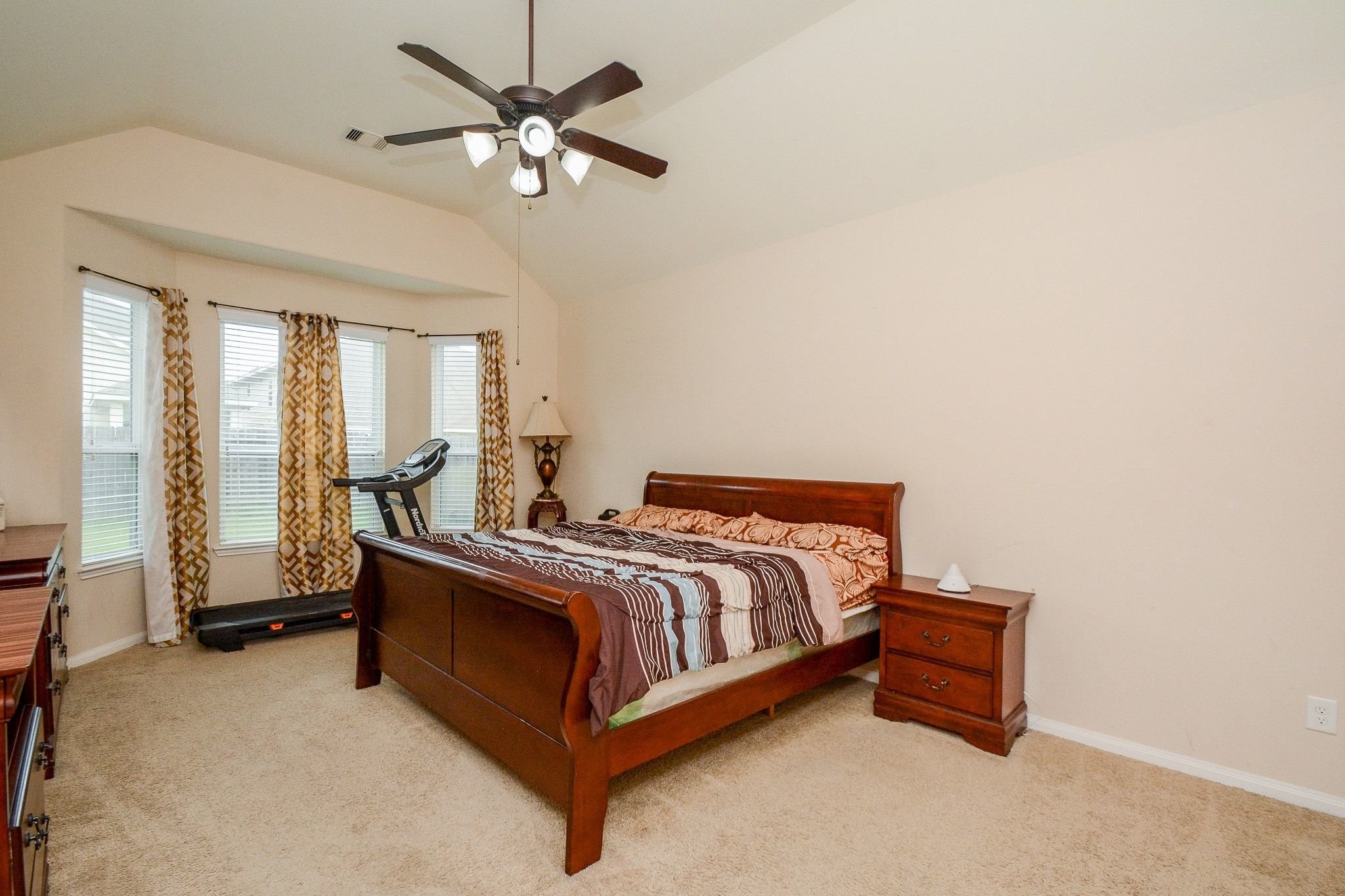 7046 Sliding Rock Circle Spring, TX 77379 - Photo 16 of 41 Experience tranquility in this bright, spacious primary bedroom with plush carpet and a stylish ceiling fan.