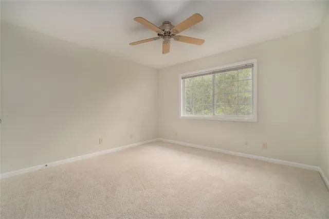 an empty room with a window and a ceiling fan