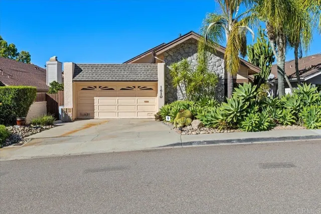 front view of a house with a yard and a garage