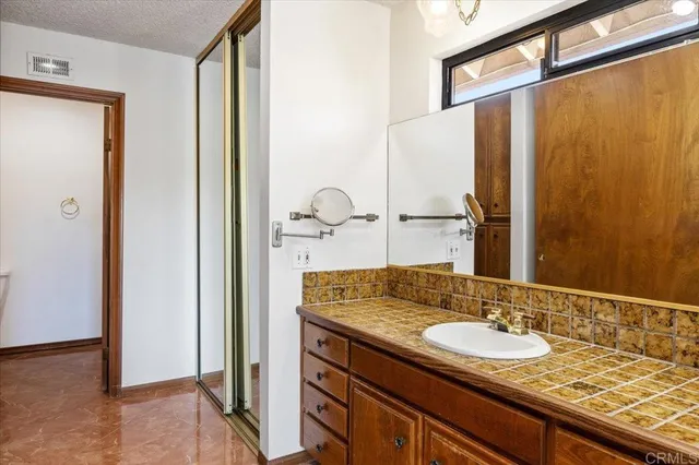 a bathroom with a granite countertop sink and a mirror