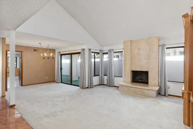 an empty room with fireplace and windows