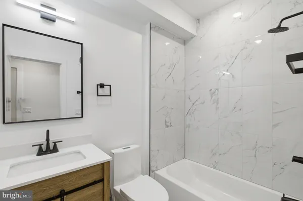 a bathroom with a sink vanity mirror and toilet