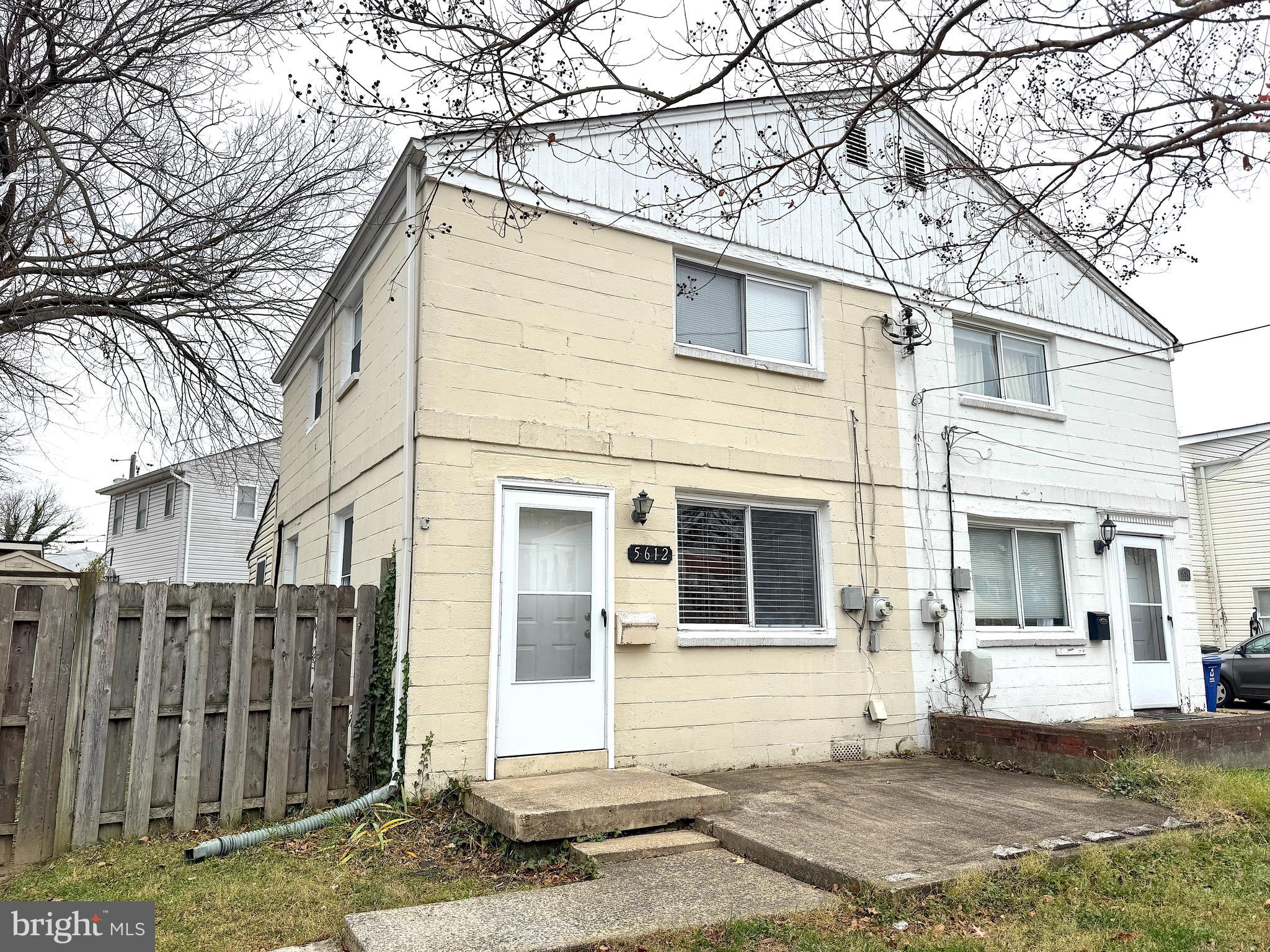a front view of a house with a tree