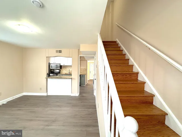 a view of entryway and kitchen with wooden floor