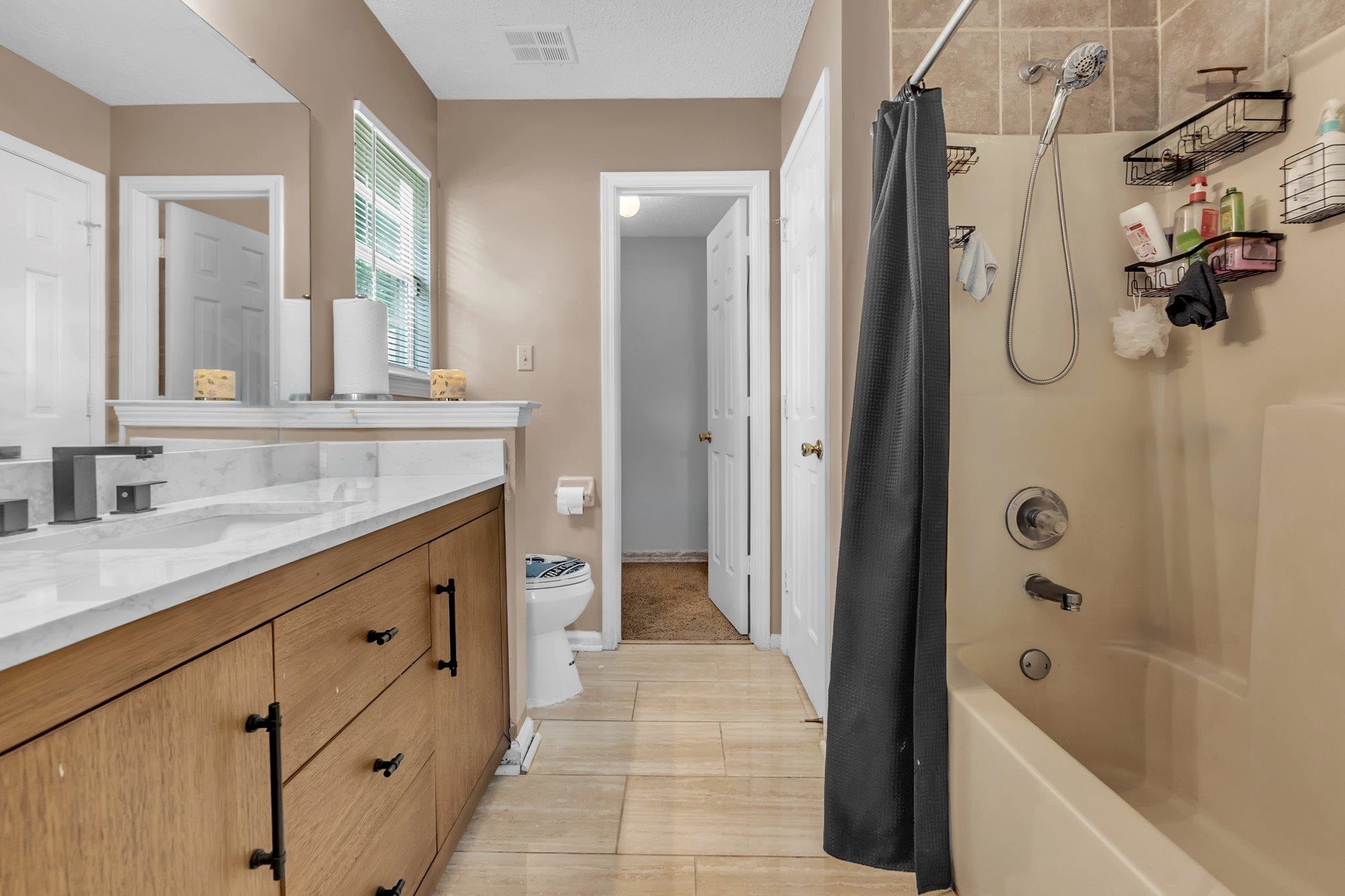 5930 Chadwell Road Millington, TN 38053 - Photo 14 of 17 Bathroom featuring a wood-finish vanity with a light-toned countertop, matte black hardware, and a framed mirror