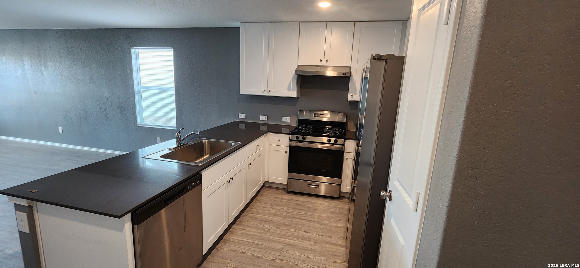 6013 Companion Loop Bulverde, TX 78163 - Photo 3 of 37 a kitchen with stainless steel appliances granite countertop a refrigerator a sink a stove and wooden floor