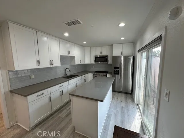 a kitchen with stainless steel appliances granite countertop a sink refrigerator and cabinets
