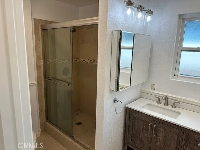 a bathroom with a mirror a double vanity sink and shower