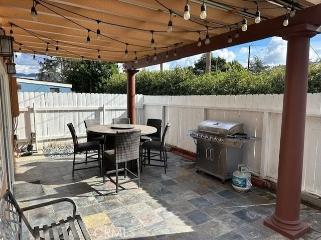 a view of a patio with table and chairs a barbeque with wooden floor