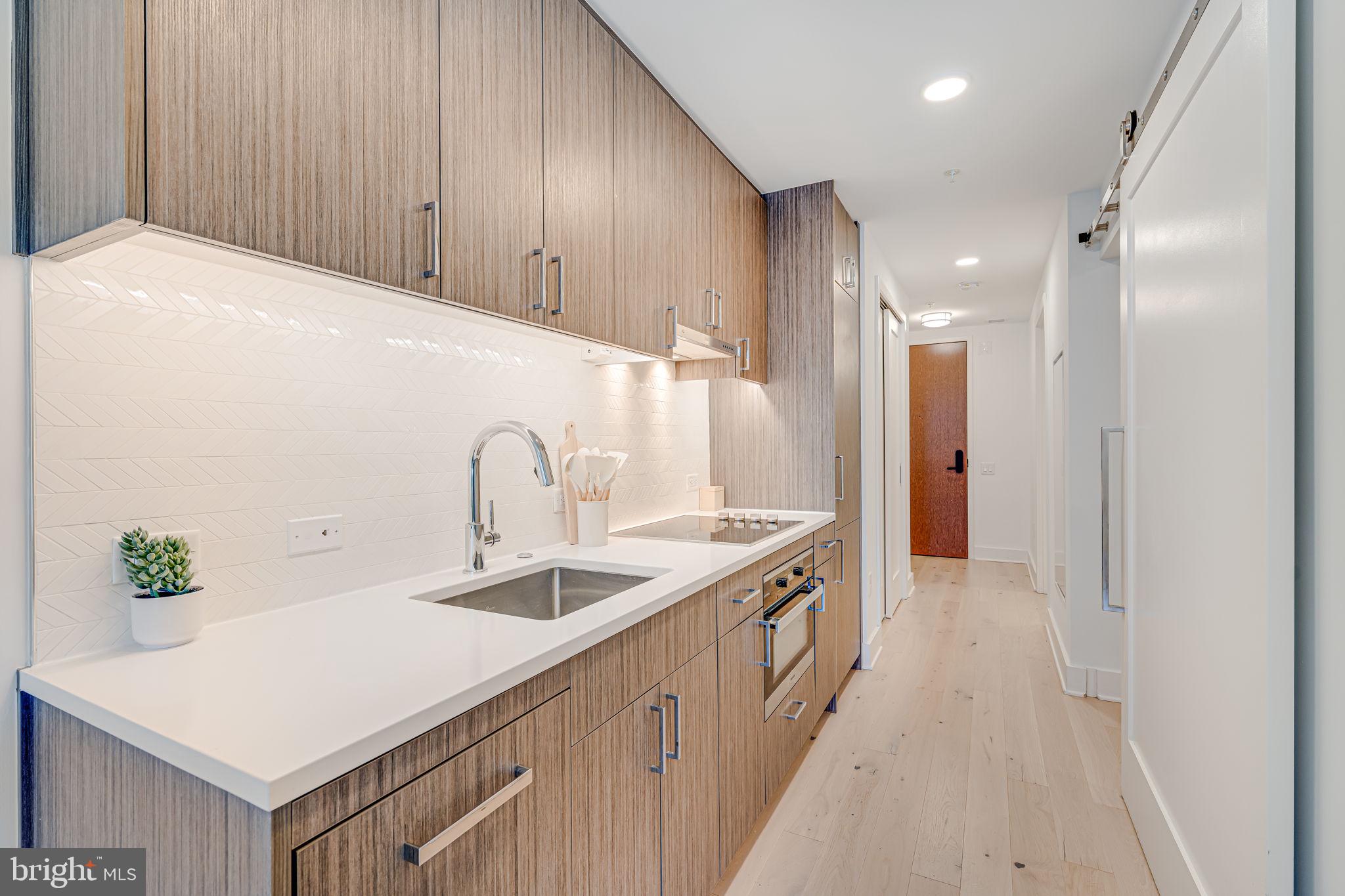1211 Van Street Southeast, Unit 309 Washington, DC 20003 - Photo 25 of 66 a kitchen with stainless steel appliances a sink and a refrigerator