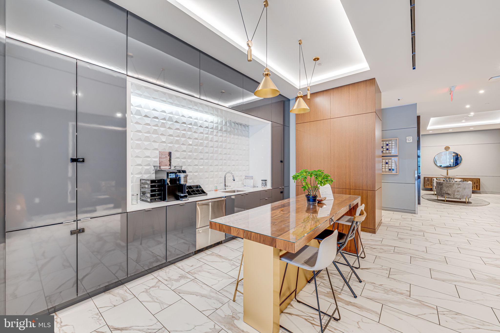 1211 Van Street Southeast, Unit 309 Washington, DC 20003 - Photo 4 of 66 a kitchen with stainless steel appliances kitchen island granite countertop a table and chairs in it