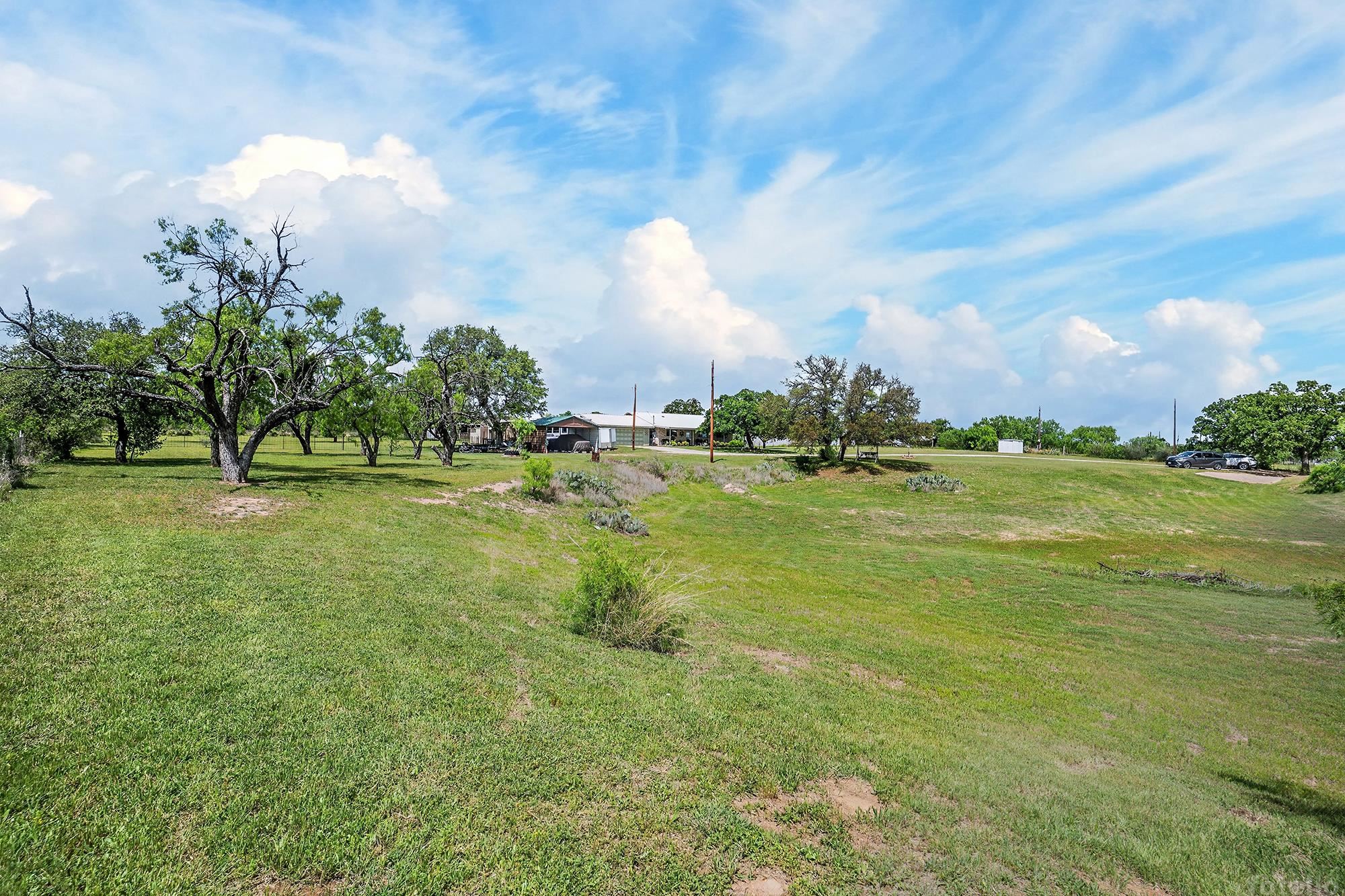 10465 Ranch To Market 1431 Buchanan Dam, TX 78609 - Photo 8 of 29 a backyard of a house with lots of green space and lake view in back