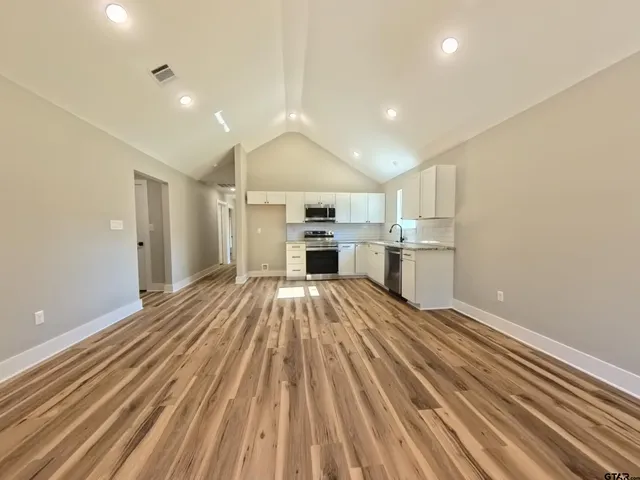 a view of kitchen with sink microwave and refrigerator