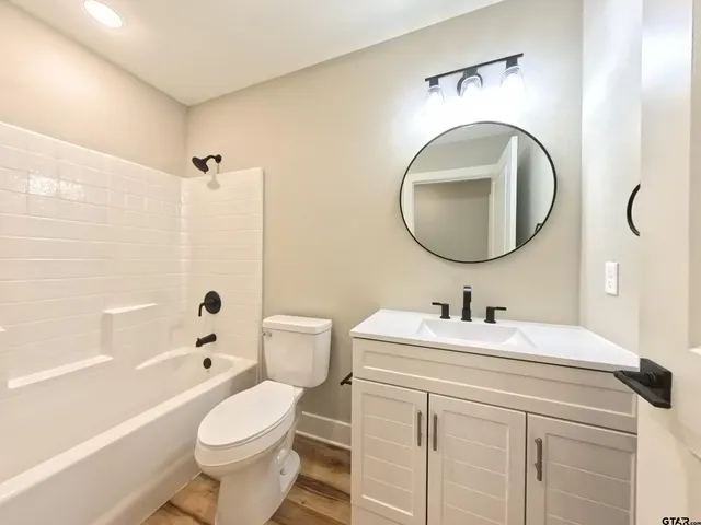 a bathroom with a sink a toilet and a mirror