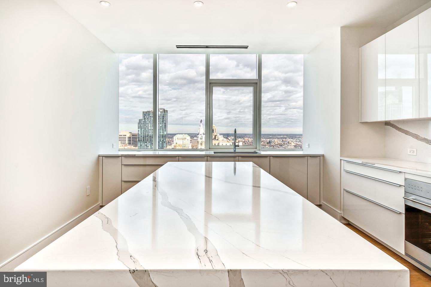 301 South Broad Street, Unit 4001 Philadelphia, PA 19107 - Photo 21 of 84 a view of a kitchen with kitchen island a large window a sink and a counter top space