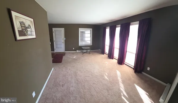 a view of a room with large windows and furniture