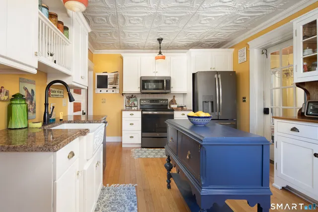 a kitchen with stainless steel appliances granite countertop a stove refrigerator and a sink