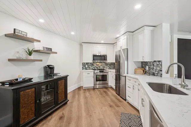 a kitchen with stainless steel appliances a stove sink and refrigerator