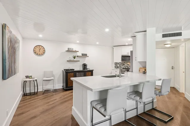 a kitchen with a dining table chairs and white cabinets