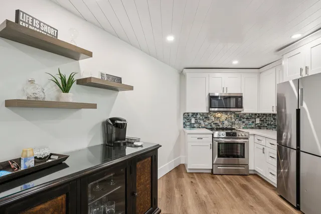 a kitchen with stainless steel appliances a stove refrigerator sink and cabinets