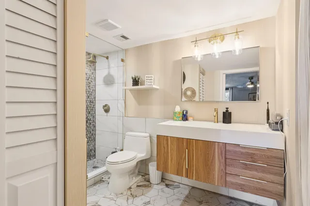 a bathroom with a toilet a sink and mirror