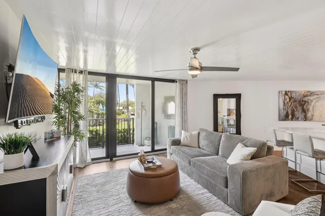a living room with furniture a flat screen tv and a large window