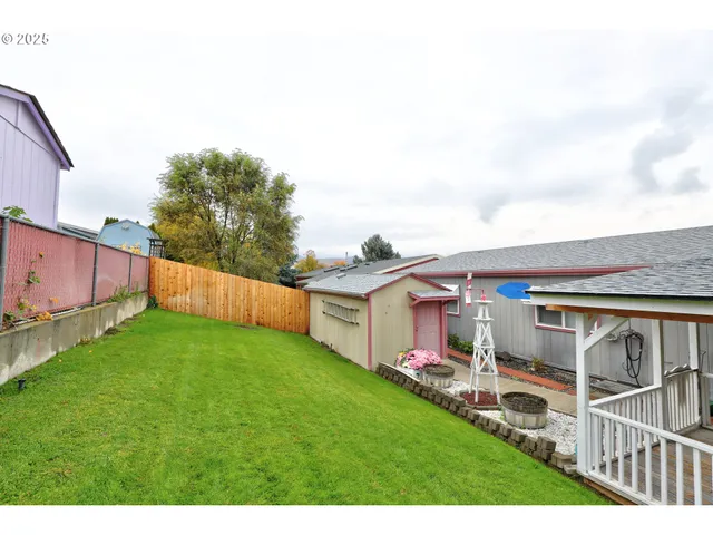 a view of backyard with table and chairs and wooden fence