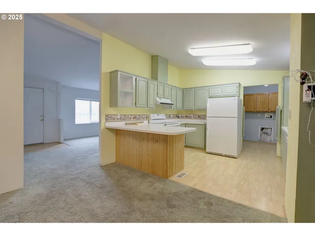 a kitchen with a refrigerator sink and cabinets