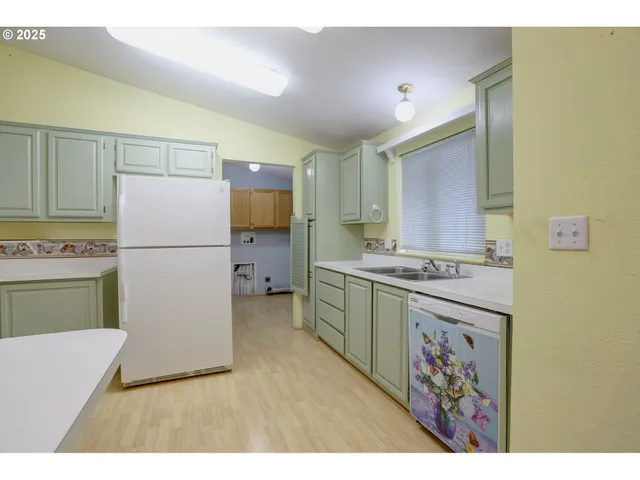 a kitchen with a refrigerator a stove top oven and a sink