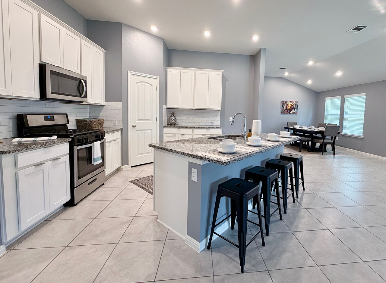 1005 Sundrops Street Leander, TX 78641 - Photo 12 of 39 a kitchen with stainless steel appliances granite countertop a stove a sink a microwave and a refrigerator